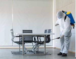 Worker sanitizing public office area